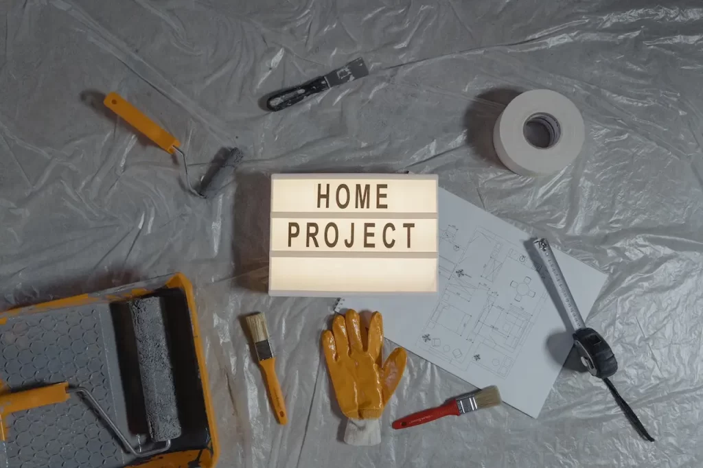 A home project sign surrounded buy painting stuff.