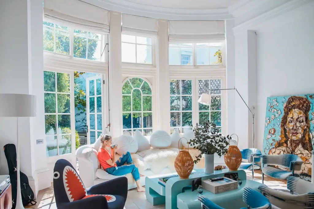 A girl is sitting in a huge bright wight living room
