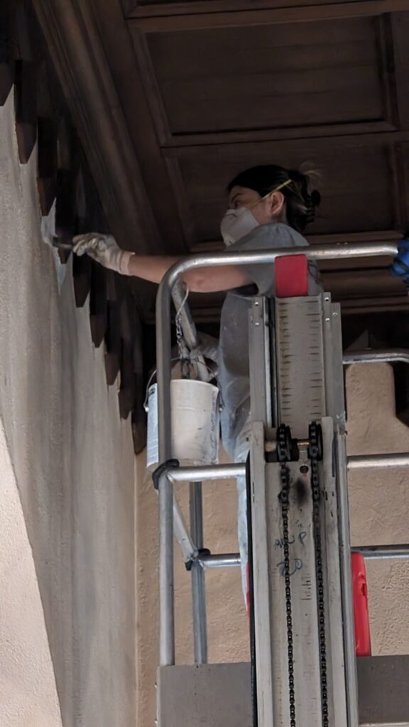 A painter is doing a nice finishes near the wall bareliefs.