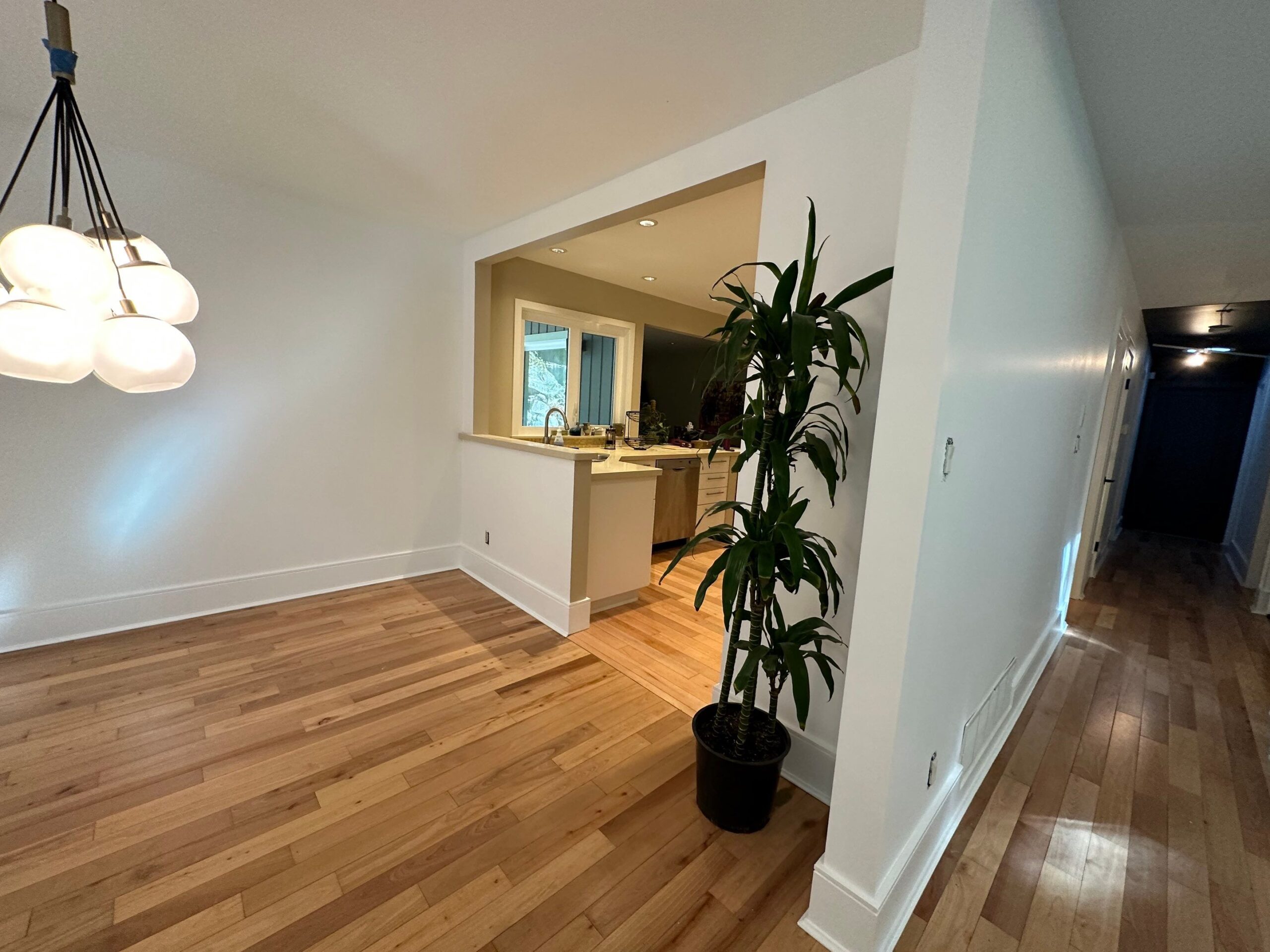 Bright room with freshly painted white walls, located before the kitchen, showcasing professional interior painting for a clean and refreshed look