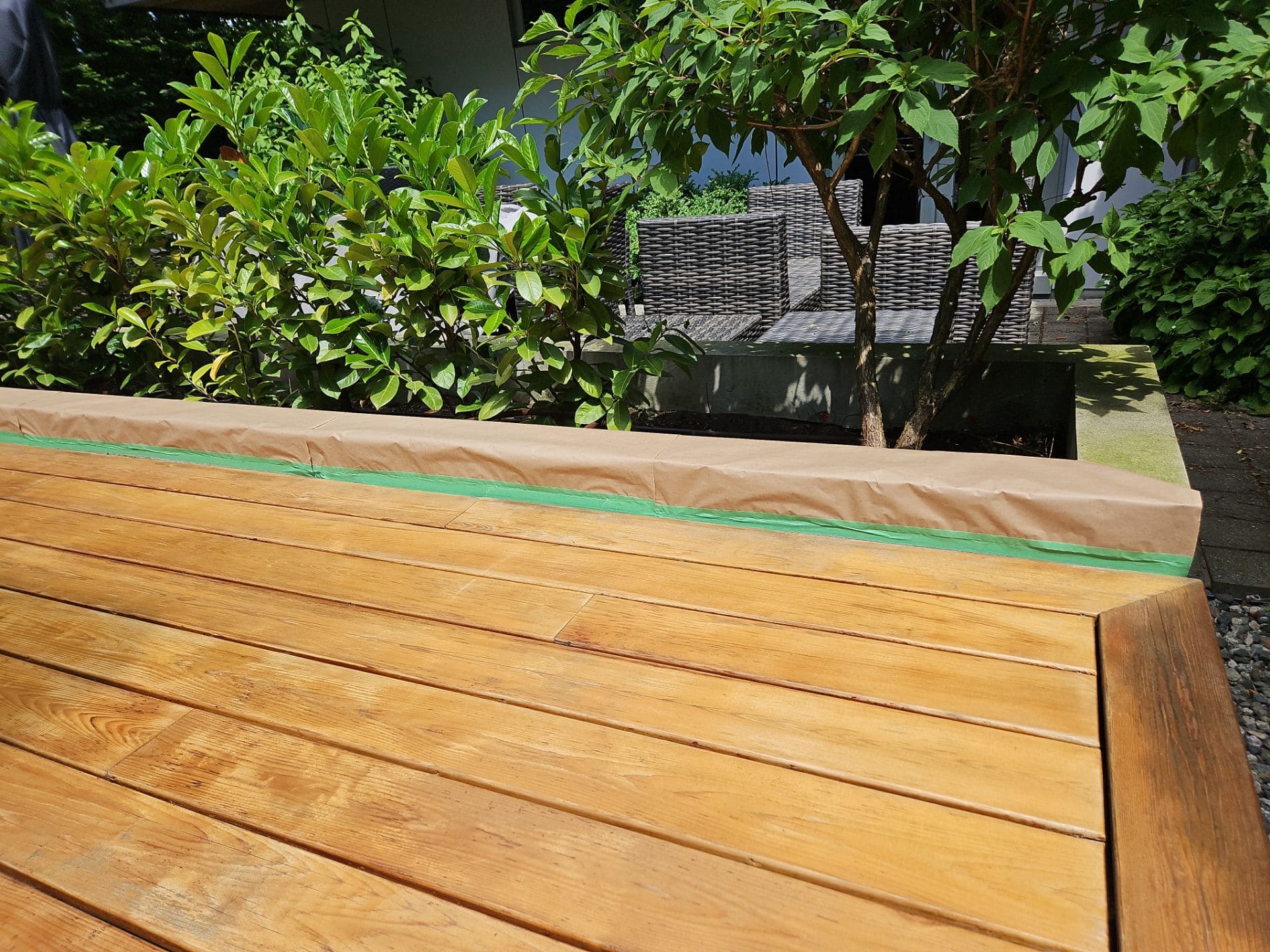 Wooden bench on deck with green tape, deck maintenance and restoration work