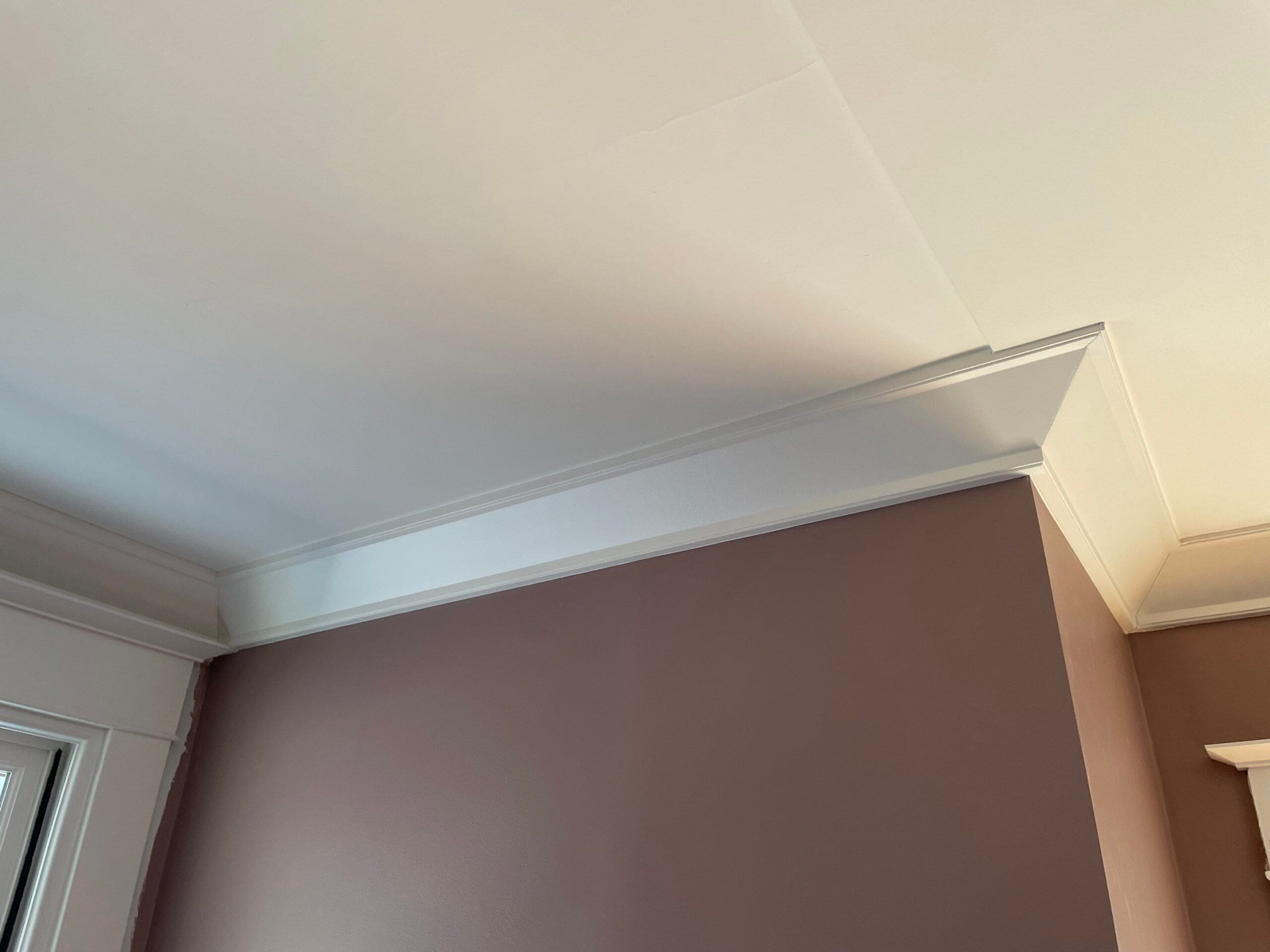 White ceiling with classic crown molding trim, professional installation