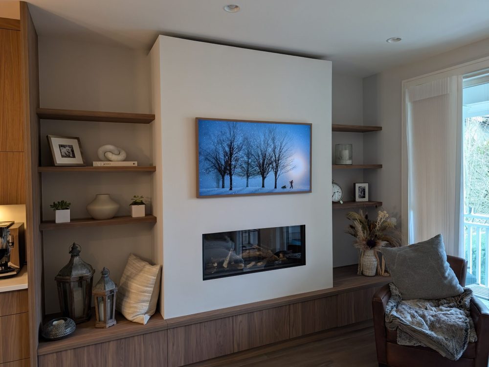 Modern living room with built-in fireplace, wood shelving, and cozy decor featuring neutral tones and soft textures."