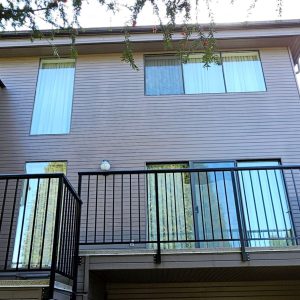 Balcony with metal railing among greenery illustrating balcony carpentry and construction services