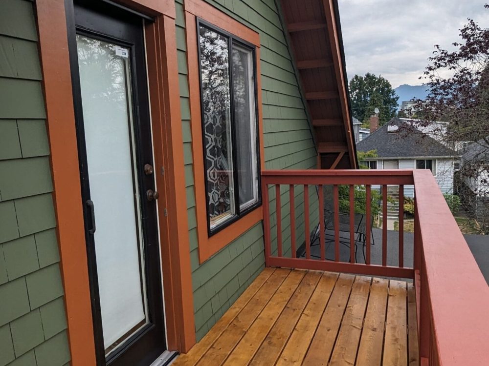 Wooden deck with red railing and house, deck restoration service