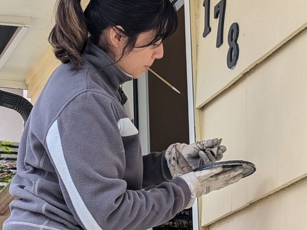 Renaissance painting worker is painting a house numbers near the doors