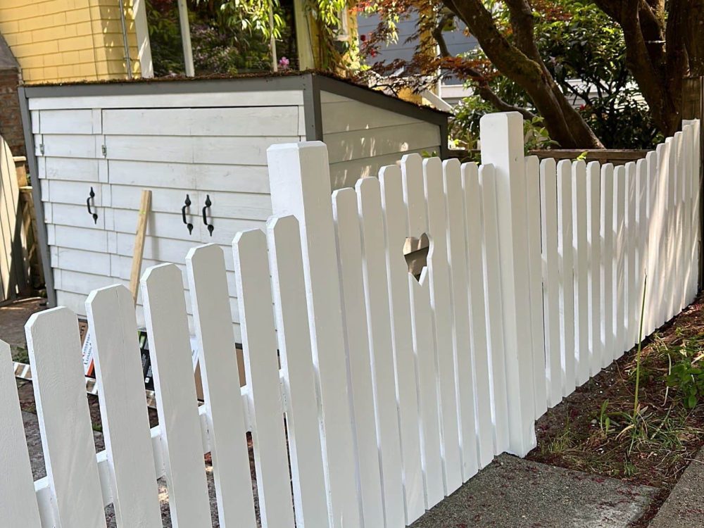 White picket fence fully restored with painting and post replacement