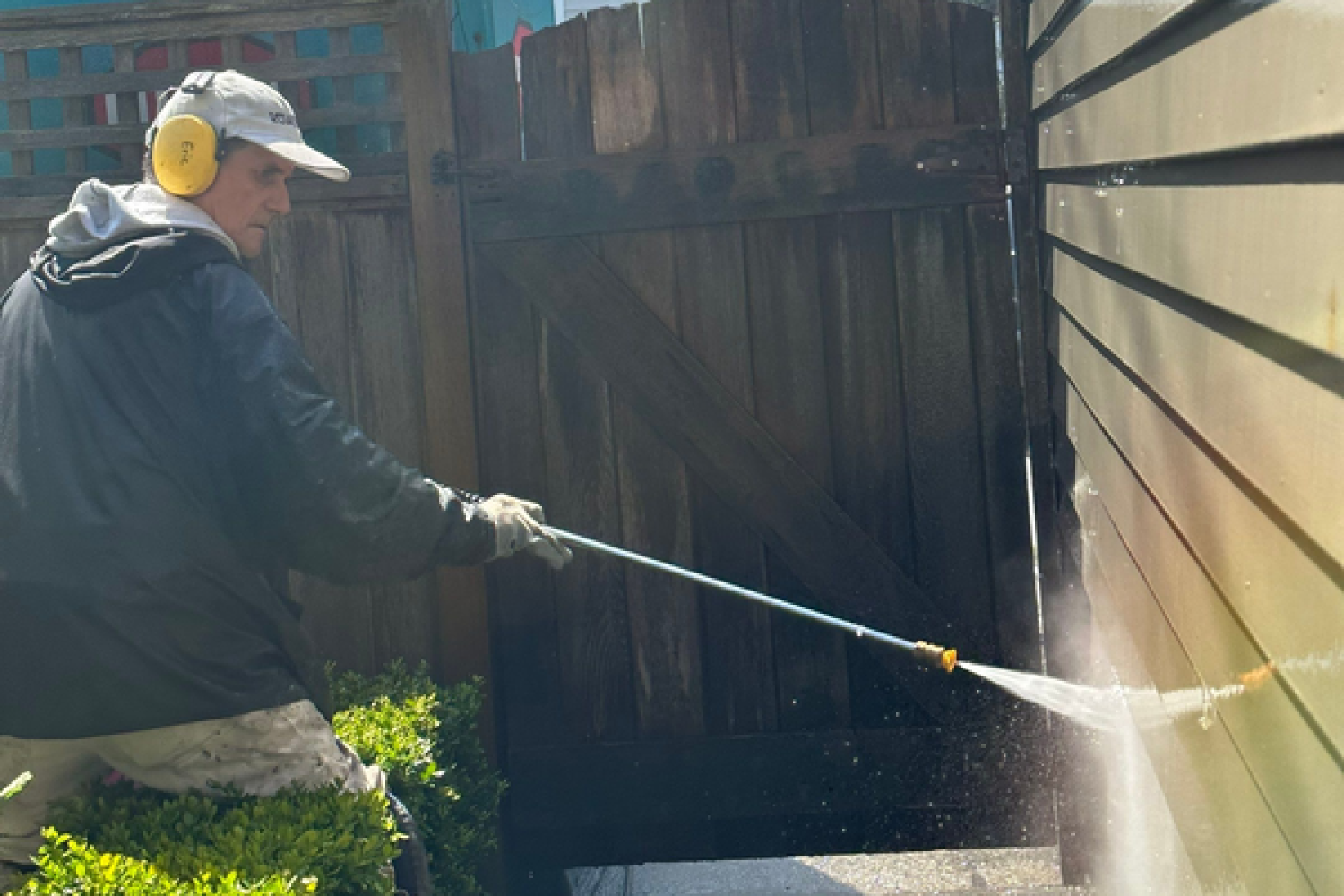 Siding pressure washing by a renaissance painting worker.